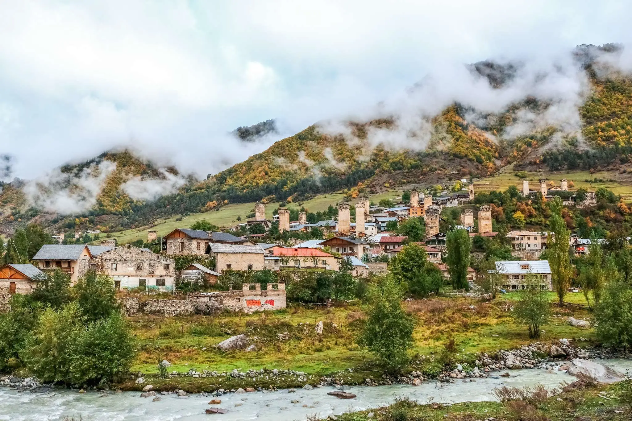 Mestia met Svaneetische torens en herfstige bergen in Georgië