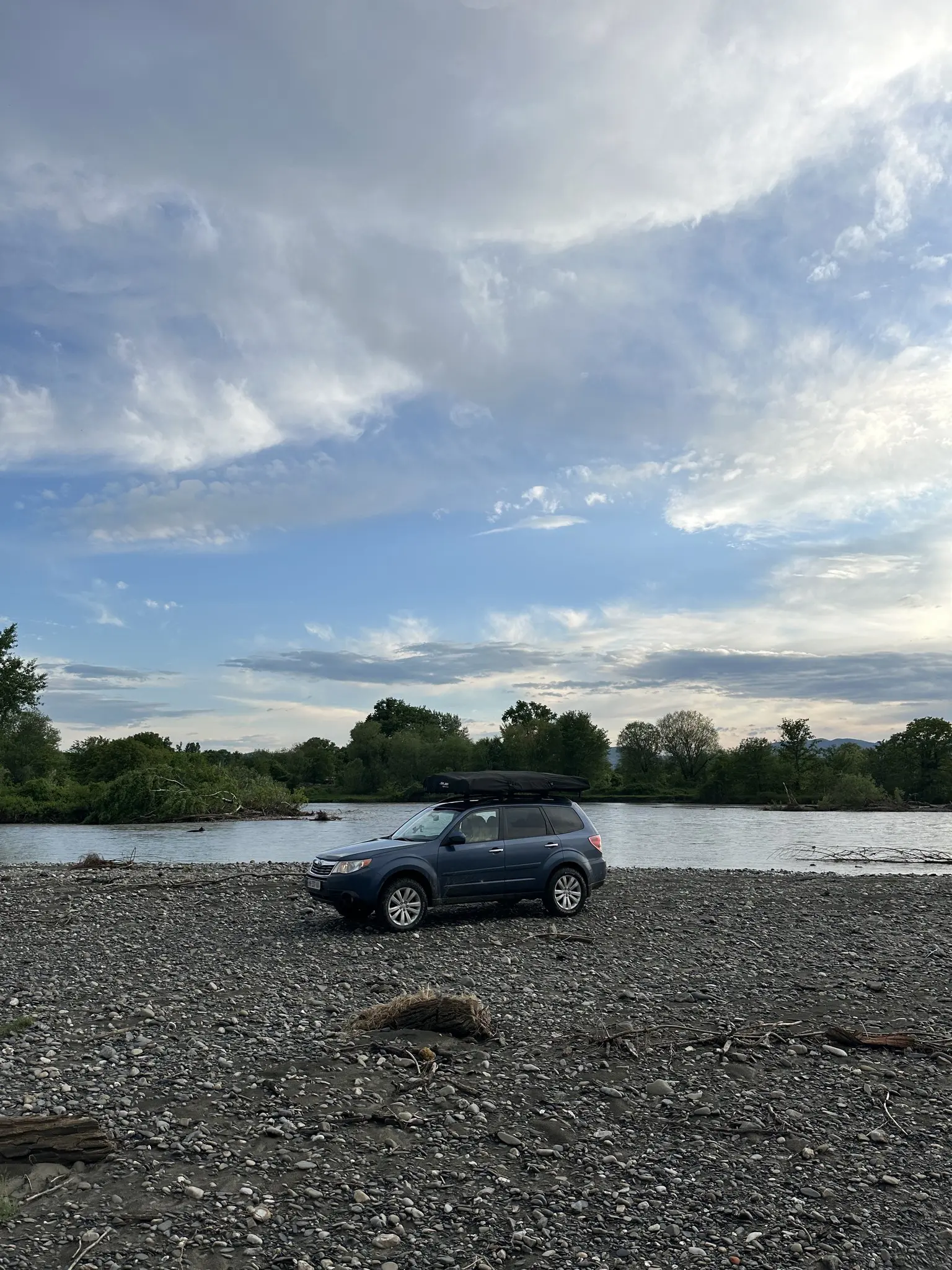 blue subaru forester with roof tent parked by a river in Georgia