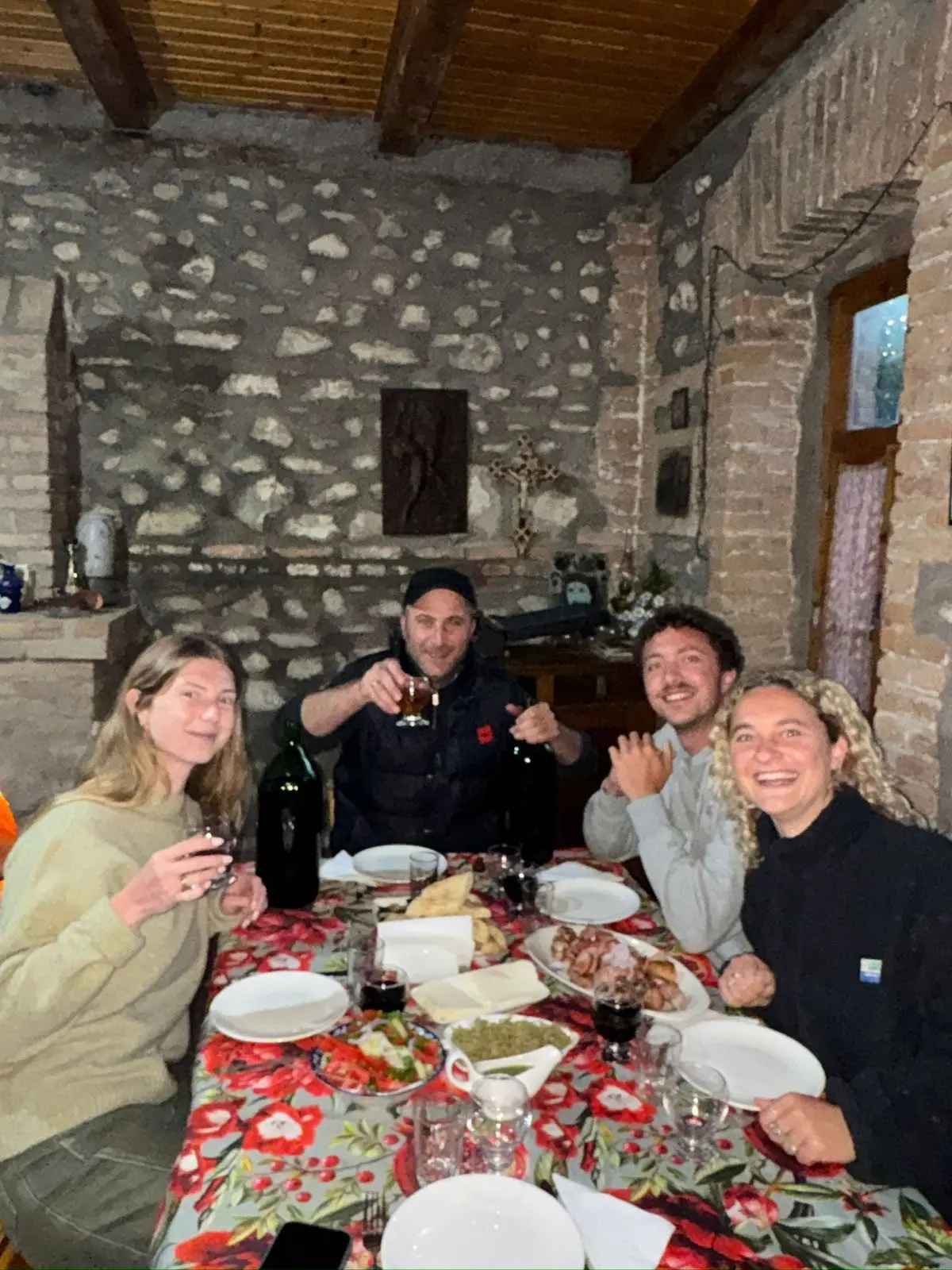 four friends enjoying a traditional Georgian dinner indoors