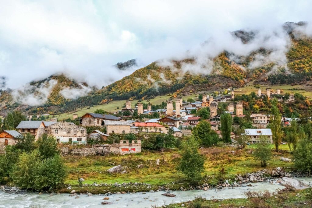 Village perché dans les montagnes avec des nuages en Géorgie
